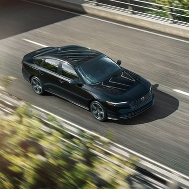 2026 Honda Accord in Crystal Black Pearl driving along overpass.